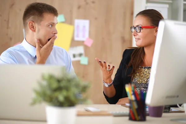 Fashion designers working in studio sitting on the desk — Stock Photo, Image