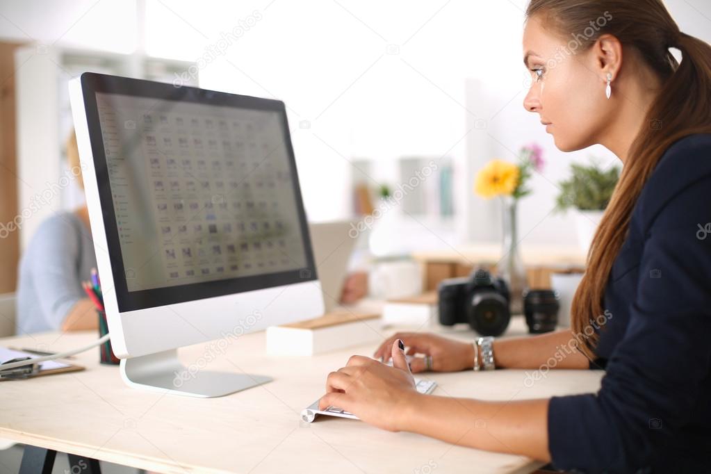 Young woman working in office, sitting at desk