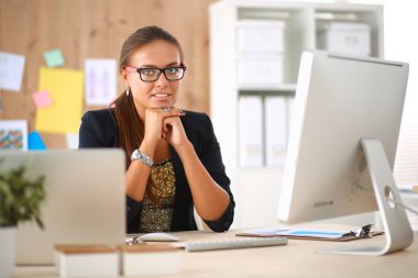 Moda tasarımcıları stüdyoda çalışıyor. Masanın üzerinde oturuyorlar.