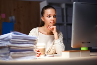 Ofiste çalışan genç kadın masada oturan ve telefonda konuşmak