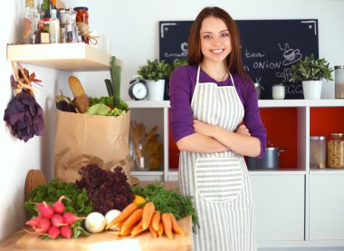 Onun mutfak masa alışveriş torbaları ile yakın duran genç kadın