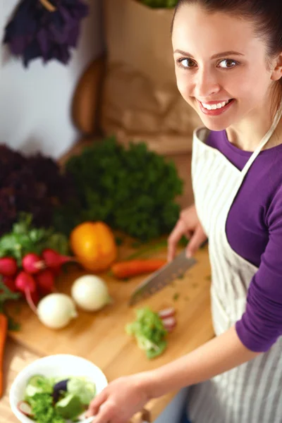 Young woman cutting vegetables in the kitchen — Stock Photo, Image