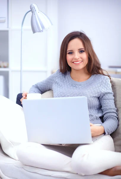Mulher bonita feliz usando laptop sentado no sofá — Fotografia de Stock