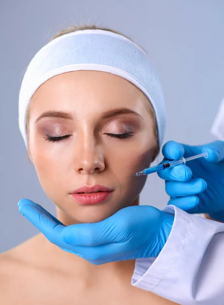 Inyección cosmética en la cara de la mujer bonita. Aislado sobre fondo gris — Foto de Stock