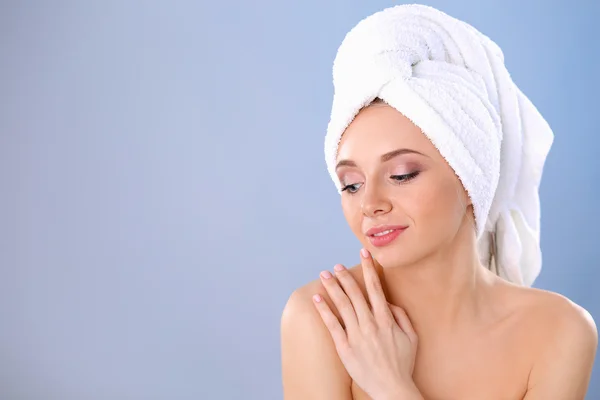 Beautiful woman with a towel on her head on a gray background — Stock Photo, Image