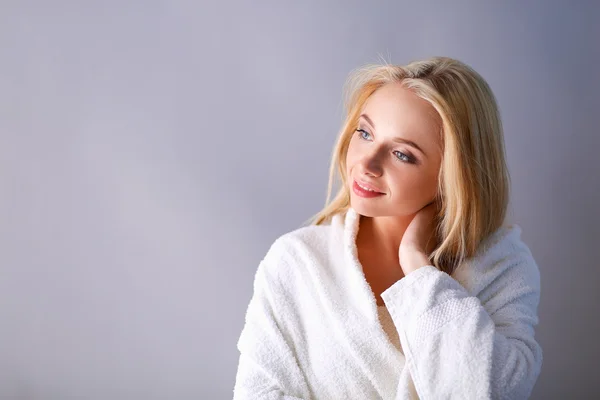 Lachende vrouw in witte badjas — Stockfoto