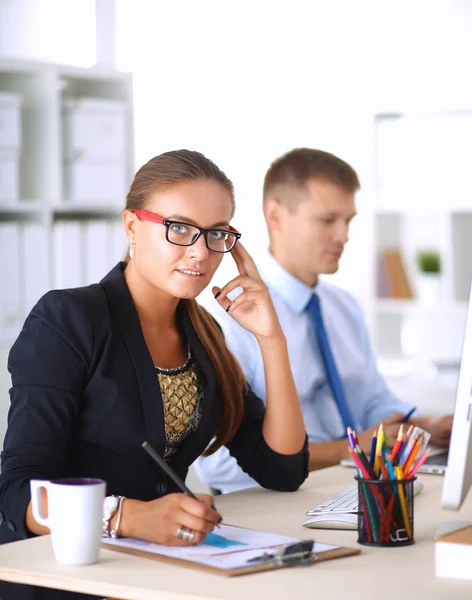 Fashion designers working in studio sitting on the desk — Stock Photo, Image