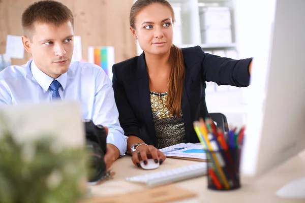 Fashion designers working in studio sitting on the desk — Stock Photo, Image