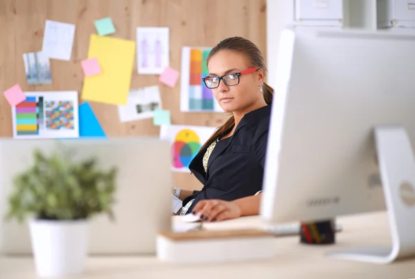 Modeskapare som arbetar i studio sittande på skrivbordet — Stockfoto