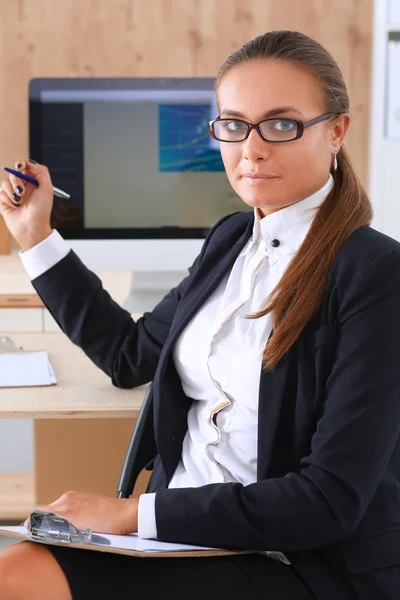 Jonge vrouw werkt in het kantoor, zit aan het bureau — Stockfoto