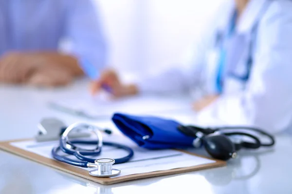 Doctor woman sitting with  male patient at the desk — Stock Photo, Image