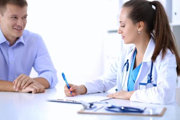 Médecin femme assise avec un patient masculin au bureau — Photo