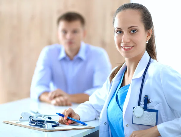 Doctor woman sitting with  male patient at the desk — Stock Photo, Image