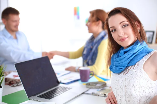 Portrait of attractive designers sitting on desk  in office — Stock Photo, Image