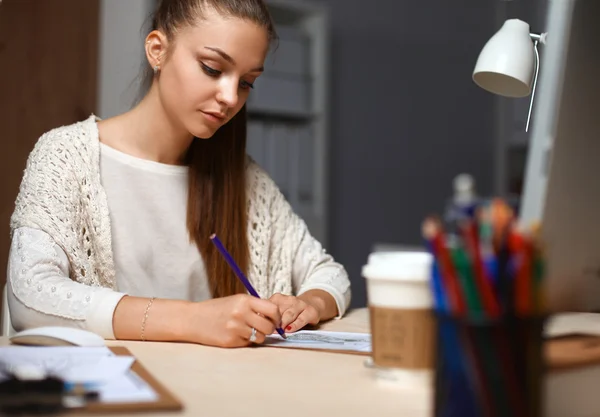 Mujer joven trabajando en la oficina, sentada en el escritorio — Foto de Stock