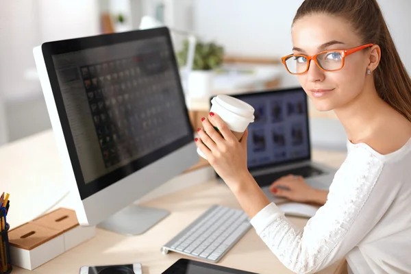 Junge Frau im Büro, am Schreibtisch sitzend — Stockfoto