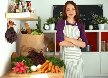 Onun mutfak masa alışveriş torbaları ile yakın duran genç kadın