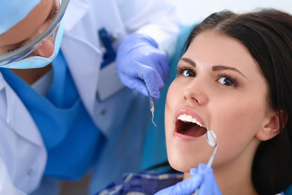 Kadın dişçi hastalarının dişlerinde çalışıyor. — Stok fotoğraf