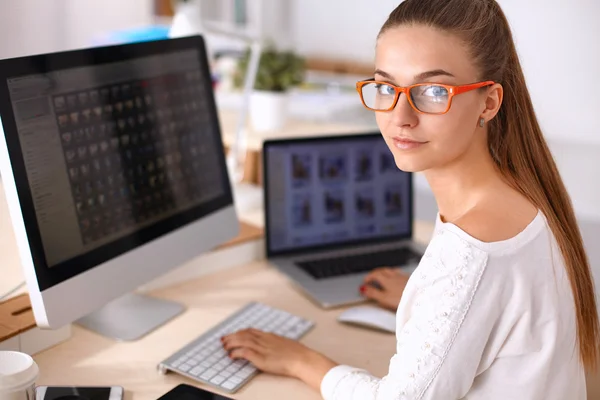 Jonge vrouw werkt in het kantoor, zit aan het bureau — Stockfoto