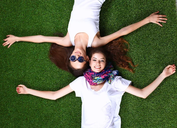 二人の可愛い女の子が緑の草の上に横たわっている — ストック写真