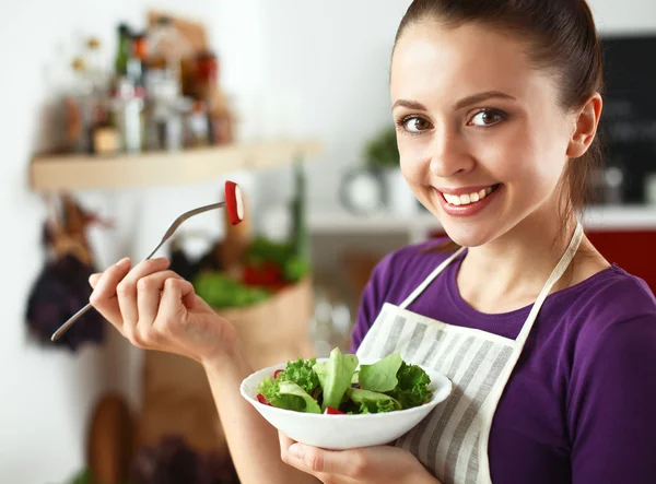 Genç kadın modern mutfakta taze salata yiyor. — Stok fotoğraf