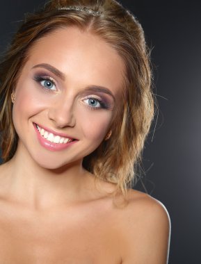 Koyu arka plan üzerinde kıvırcık uzun saçlı güzel kadın