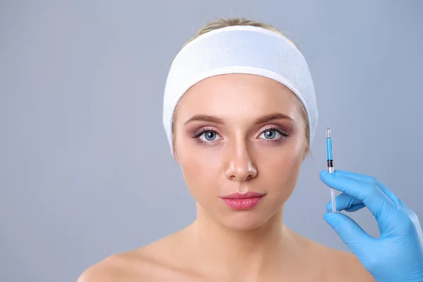 Cosmetische injectie op de mooie vrouw gezicht. Geïsoleerd op een grijze achtergrond — Stockfoto