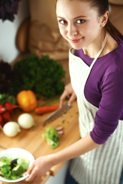 Young woman cutting vegetables in the kitchen