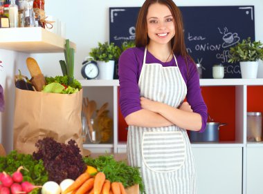 Onun mutfak masa alışveriş torbaları ile yakın duran genç kadın