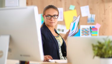 Moda tasarımcıları stüdyoda çalışıyor. Masanın üzerinde oturuyorlar.