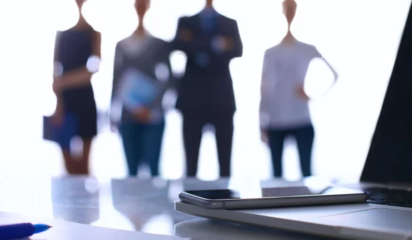 Laptop  computer on  desk ,  businesspeople standing in the background — Stock Photo, Image