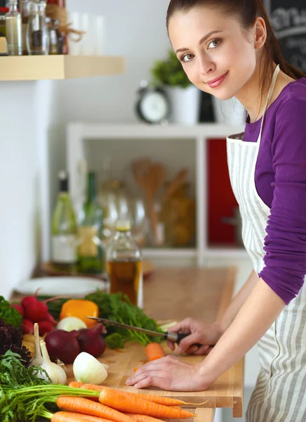 Young woman cutting vegetables in the kitchen — Stock Photo, Image