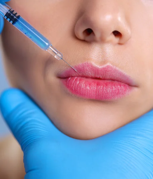 Injeção cosmética no rosto da mulher bonita. Isolado em fundo cinza — Fotografia de Stock