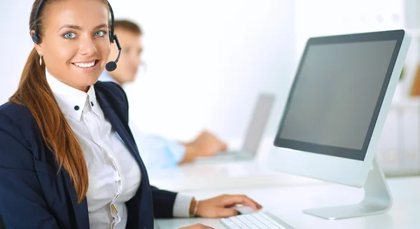 Happy female wearing headset and sitting on the desk — Stock Photo, Image