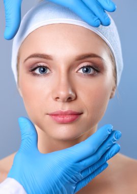 Güzel kadın yüz kozmetik enjeksiyon. Gri arka plan üzerinde izole