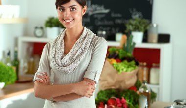 Masasının yanında duran genç bir kadın.