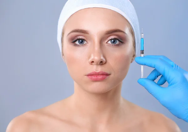 Kosmetická injekce na tváři hezká žena. Izolované na šedém pozadí — Stock fotografie