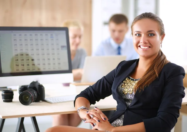 Jonge vrouw werkt in het kantoor, zit aan het bureau — Stockfoto