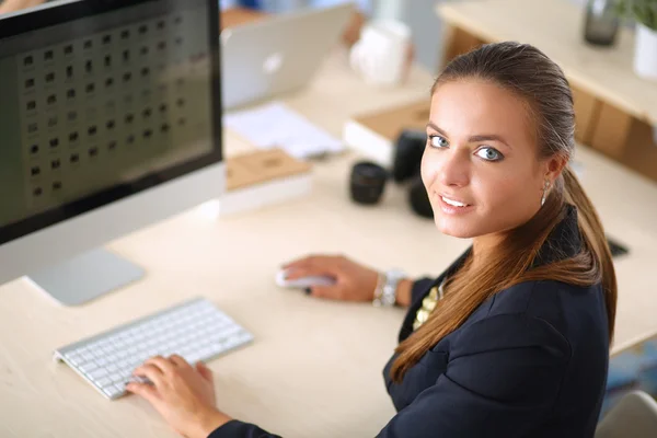 Młoda kobieta pracuje w biurze, siedzi przy biurku — Zdjęcie stockowe