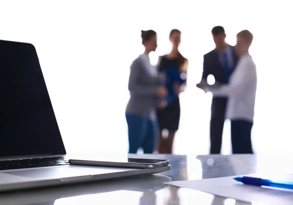 Laptop auf dem Schreibtisch, Geschäftsleute im Hintergrund — Stockfoto