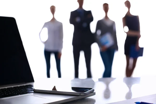 Laptop  computer on  desk ,  businesspeople standing in the background — Stock Photo, Image