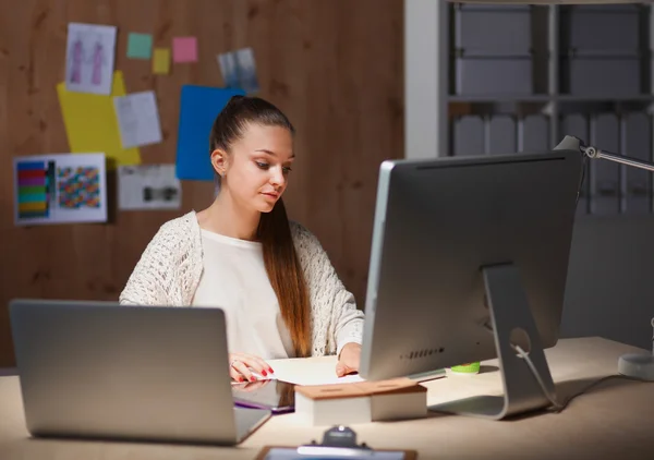 Mujer joven trabajando en la oficina, sentada en el escritorio — Foto de Stock