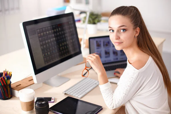 Jonge vrouw werkt in het kantoor, zit aan het bureau — Stockfoto