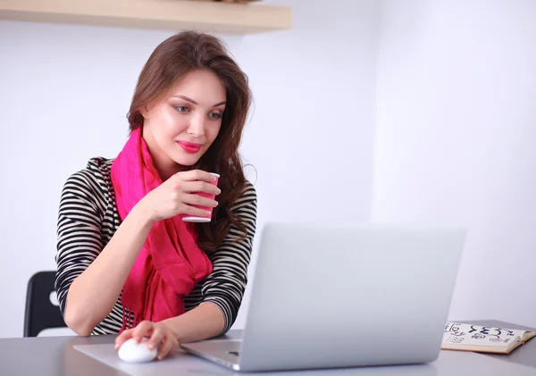 Portret van een Glimlachende zakenvrouw met koffie cup voor laptop — Stockfoto