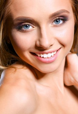 Koyu arka plan üzerinde kıvırcık uzun saçlı güzel kadın