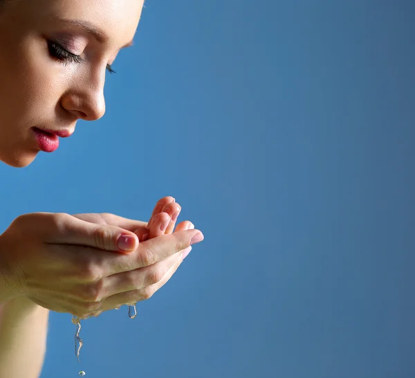 Jeune femme se lave le visage avec de l'eau claire — Photo