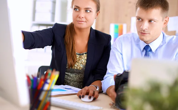 Fashion designers working in studio sitting on the desk — Stock Photo, Image