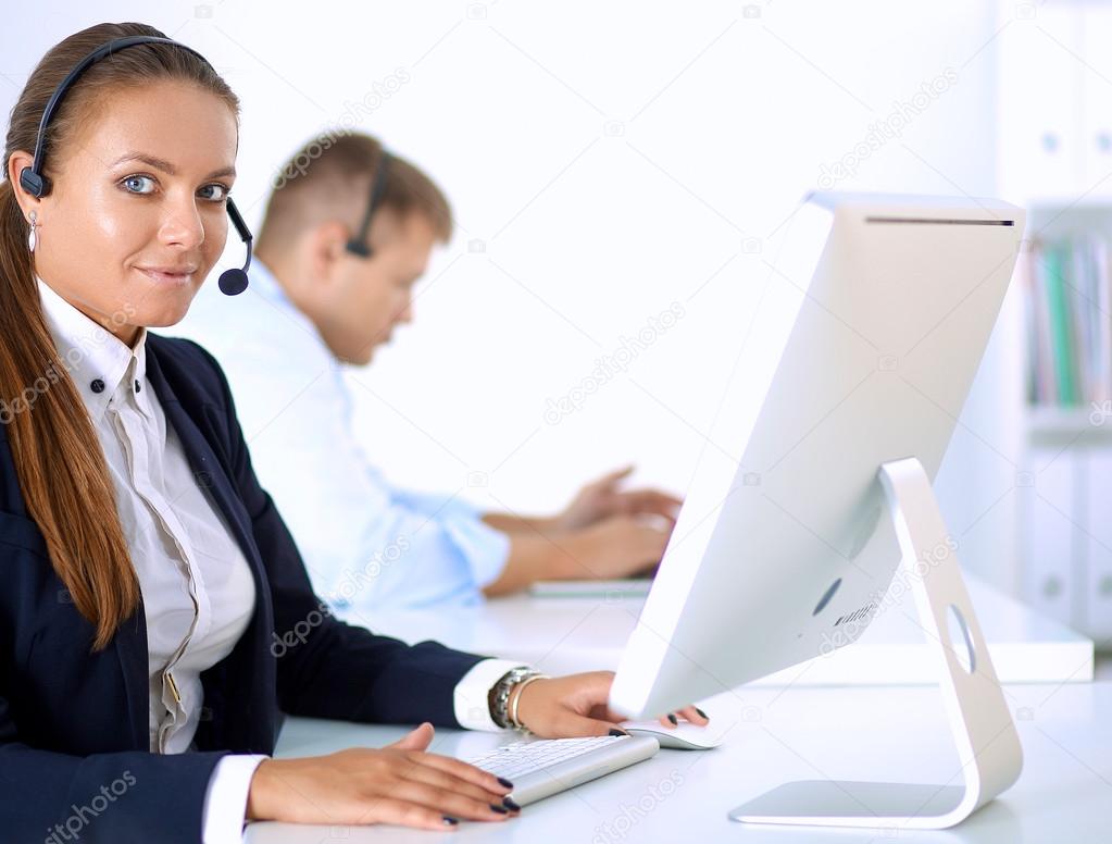 Happy female wearing headset and sitting on the desk