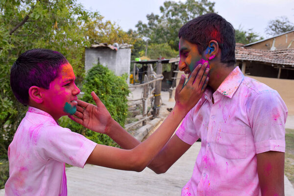 два мальчика играют в цветах в счастливой позе, концепция для индийского фестиваля Холи