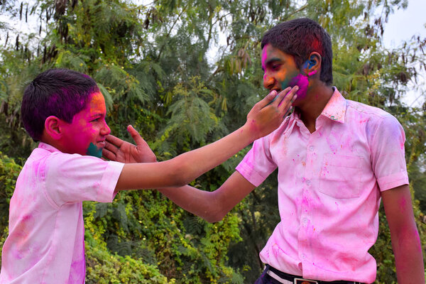 два мальчика играют в цветах в счастливой позе, концепция для индийского фестиваля Холи